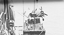 USS Kitty Hawk at Pallikulo Bay, New Hebrides, unloading torpedo plane to self-propelled 50-ton barge