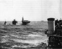 Destroyer and carrier simultaneously taking fuel from a T3 tanker on 19 December 1945. This photograph was taken from the Altahama one day after the typhoon that struck the Third Fleet capsizing several destroyers. Note the damage to the catwalk and the plane tipped behind the stack. (National Archives)