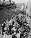 Crewmen aboard the receiving ship had to manually stow each shell. Notice that both fuel lines are just being taken aboard. [Courtesy Rear Adm. Mason Freeman, USN (Ret.)]